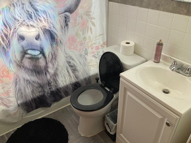 full bathroom with shower / tub combo, backsplash, vanity, tile walls, and toilet