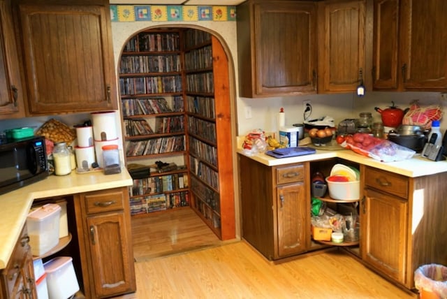 17315 Phelps Rd, Linesville, PA 16424 - kitchen featuring black microwave, light wood finished floors, light countertops, and brown cabinets