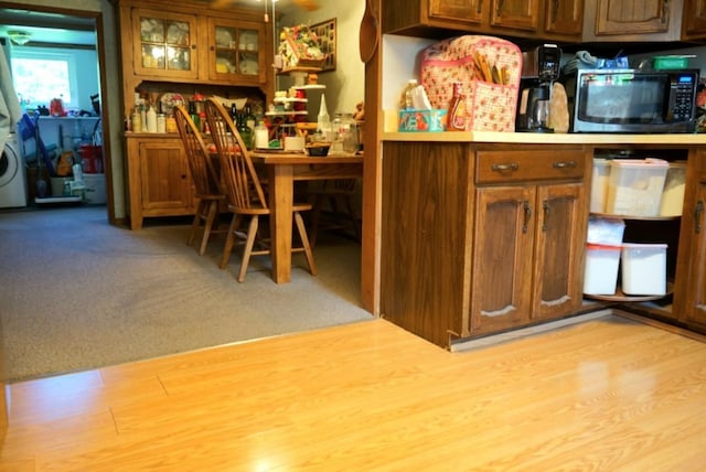 17315 Phelps Rd, Linesville, PA 16424 - kitchen with black microwave, brown cabinetry, glass insert cabinets, and light countertops