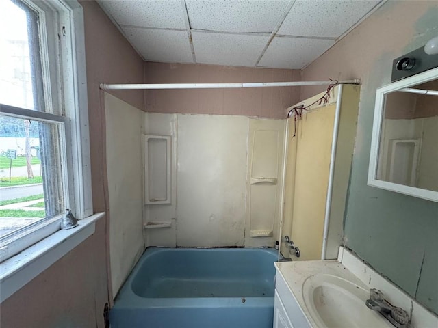 bathroom featuring vanity, a drop ceiling, and tub / shower combination