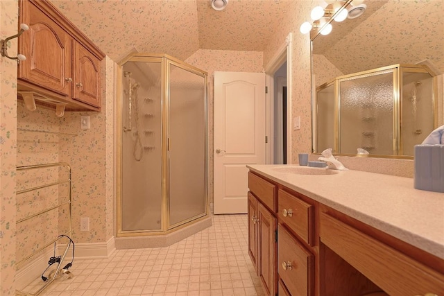 bathroom featuring vanity, a shower with shower door, and lofted ceiling