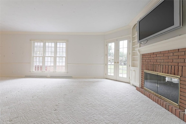 unfurnished living room featuring carpet, french doors, a brick fireplace, built in features, and ornamental molding