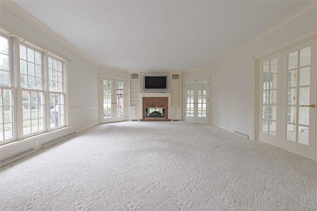 unfurnished living room with a fireplace, french doors, ornamental molding, and carpet