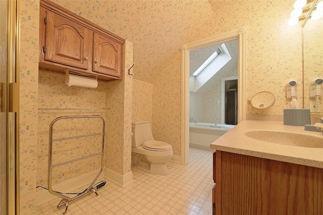 bathroom with a skylight, vanity, and toilet