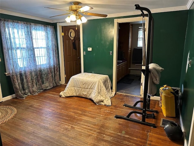 bedroom with ceiling fan, ornamental molding, wood-type flooring, and baseboards