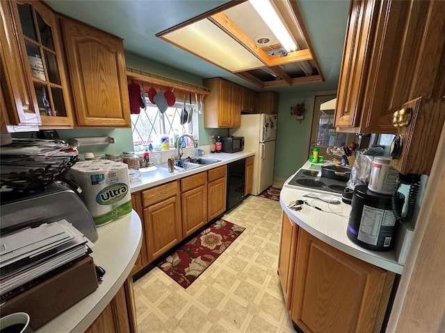 kitchen featuring a sink, light countertops, black appliances, brown cabinets, and light floors