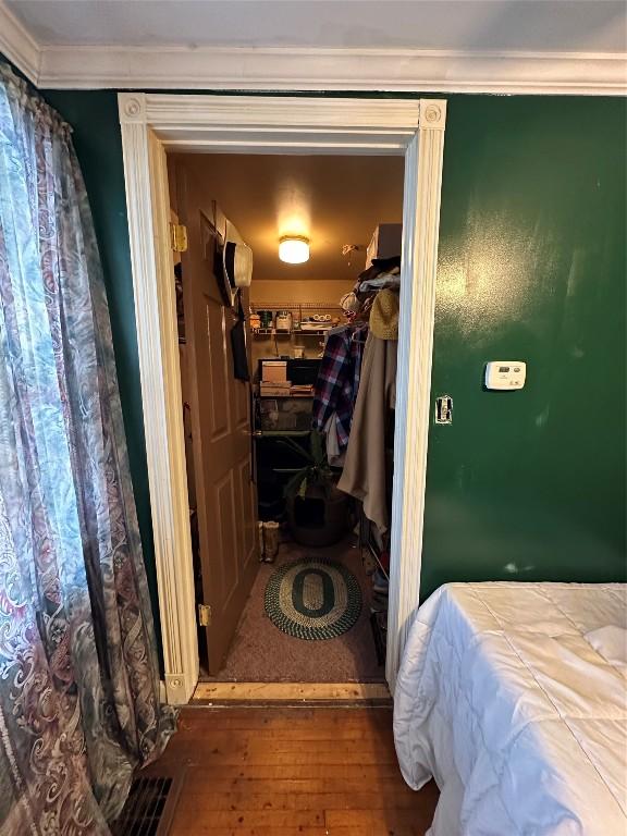 bedroom with ornamental molding, a closet, and hardwood / wood-style flooring