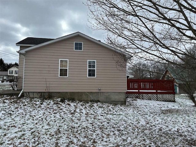 view of snow covered exterior with a wooden deck