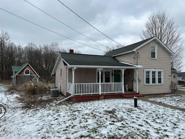 view of front of house with central air condition unit, covered porch, and a chimney