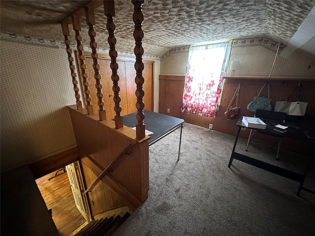 bonus room with carpet floors, wainscoting, vaulted ceiling, wooden walls, and wallpapered walls