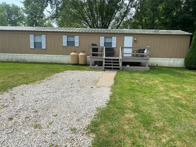 back of house featuring a lawn and a wooden deck