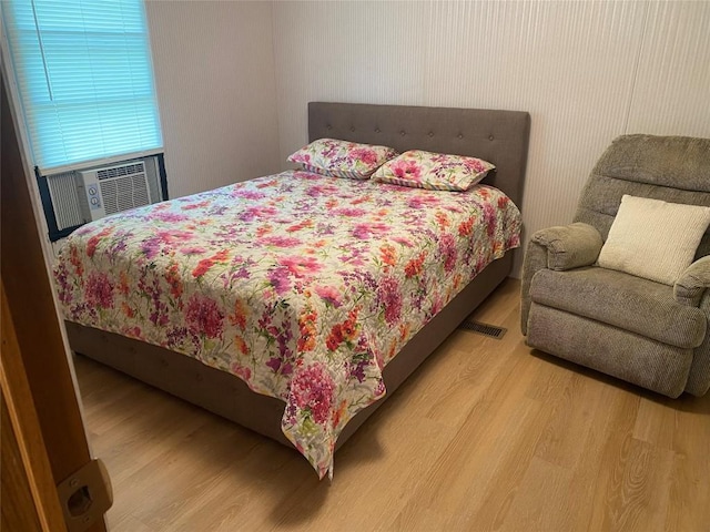 bedroom with hardwood / wood-style floors and cooling unit