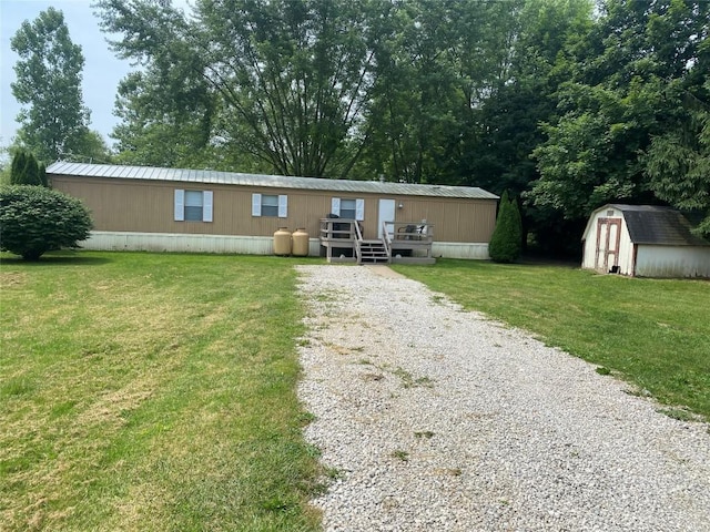 view of front facade with a storage shed, a wooden deck, and a front lawn