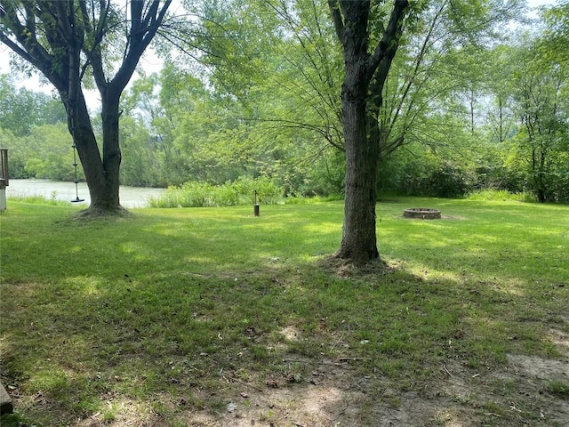 view of yard featuring a water view and an outdoor fire pit