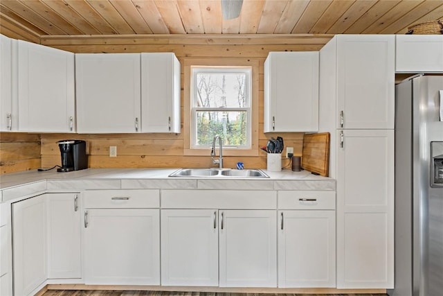 2629 River Dr, Jamestown, PA 16134 - kitchen with stainless steel refrigerator with ice dispenser, wood ceiling, white cabinetry, light countertops, and wood walls