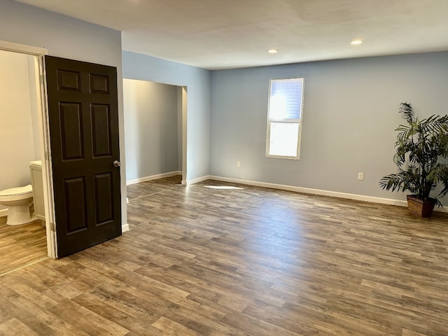 spare room featuring recessed lighting, baseboards, and wood finished floors