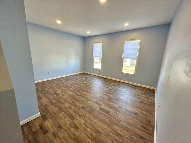 spare room with recessed lighting, wood finished floors, and baseboards