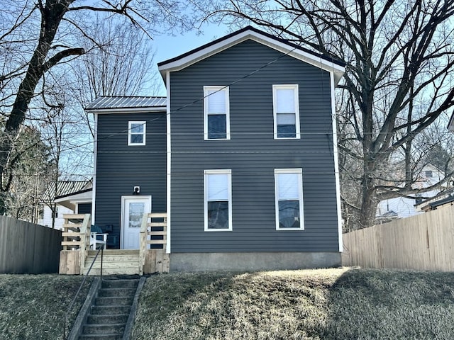 view of front of house with metal roof and fence