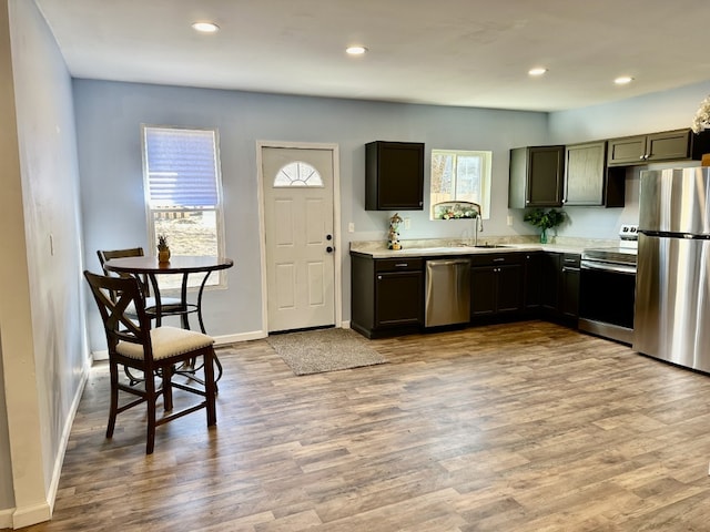 kitchen featuring a sink, recessed lighting, light wood-style floors, appliances with stainless steel finishes, and light countertops