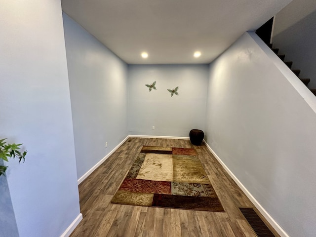 hallway with visible vents, baseboards, stairway, recessed lighting, and wood finished floors