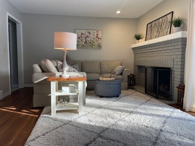 living room featuring recessed lighting, baseboards, wood finished floors, and a fireplace