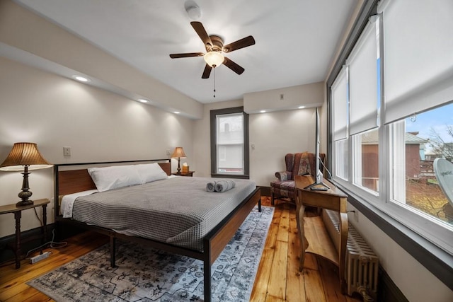 bedroom featuring ceiling fan, wood-type flooring, and radiator