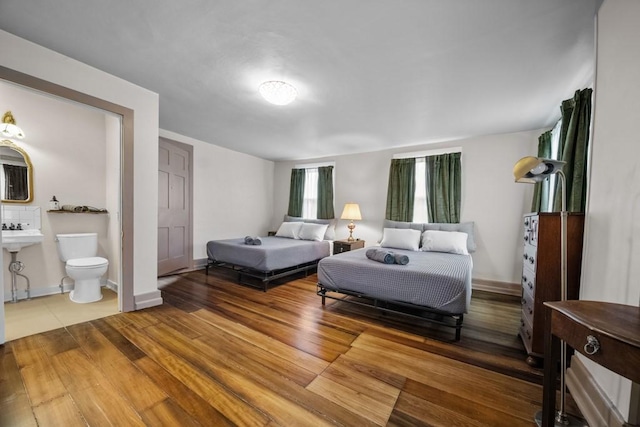 bedroom with hardwood / wood-style flooring and ensuite bathroom