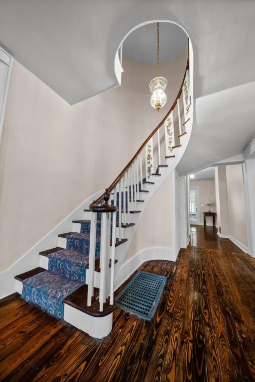 stairway featuring hardwood / wood-style flooring and a chandelier