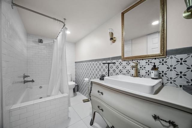 full bathroom with tile patterned flooring, shower / bath combo, toilet, and tile walls