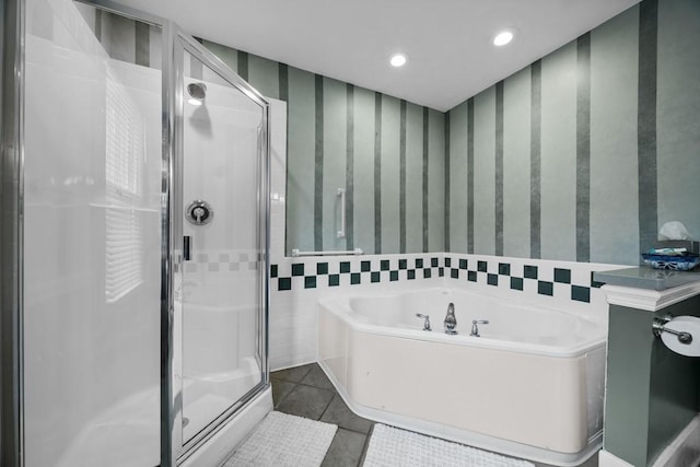 bathroom with tile patterned flooring, shower with separate bathtub, and tile walls