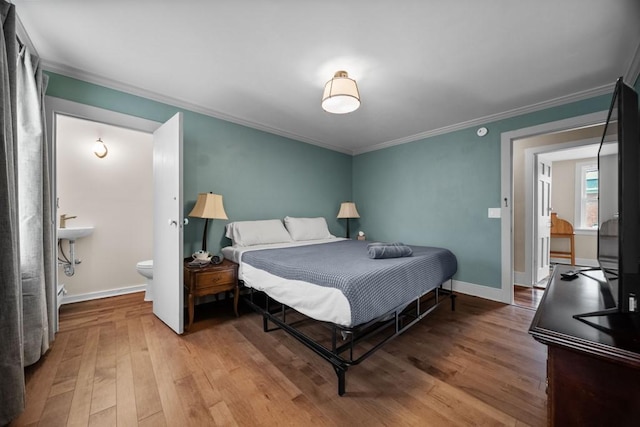 bedroom featuring wood-type flooring, connected bathroom, and crown molding