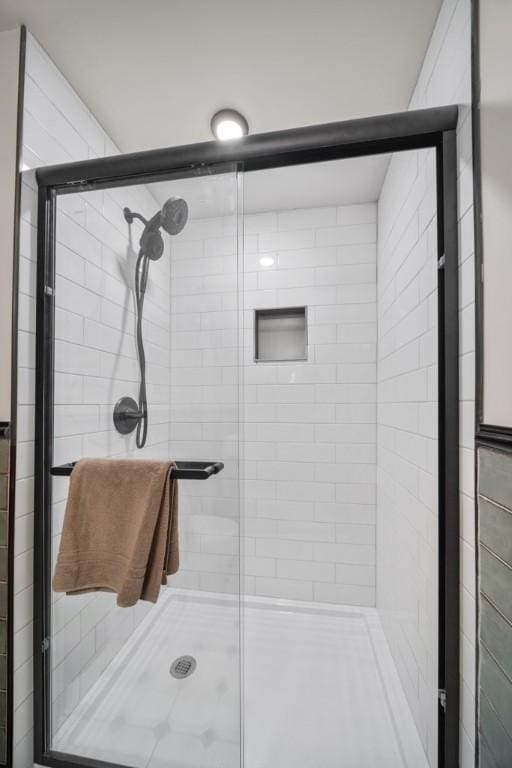 bathroom featuring a shower with shower door