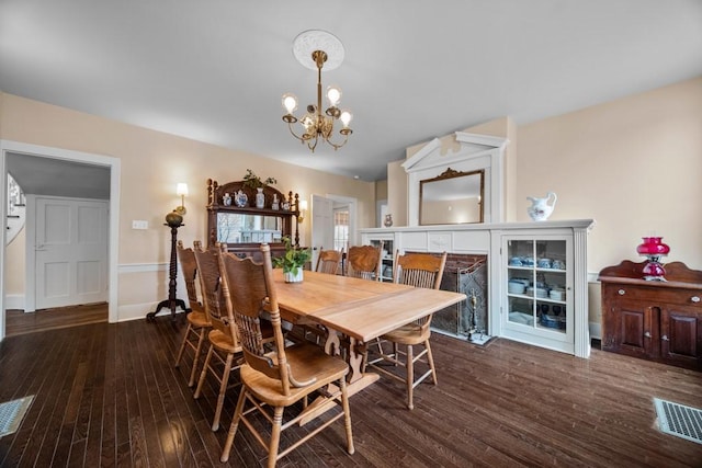 dining room featuring dark hardwood / wood-style flooring and an inviting chandelier