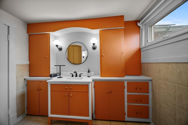 bathroom with tile patterned flooring, vanity, and tile walls