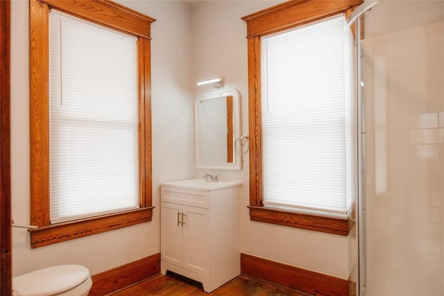 bathroom featuring walk in shower, vanity, toilet, and wood-type flooring