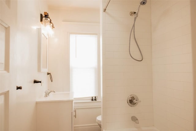 full bathroom featuring vanity, tiled shower / bath, and toilet