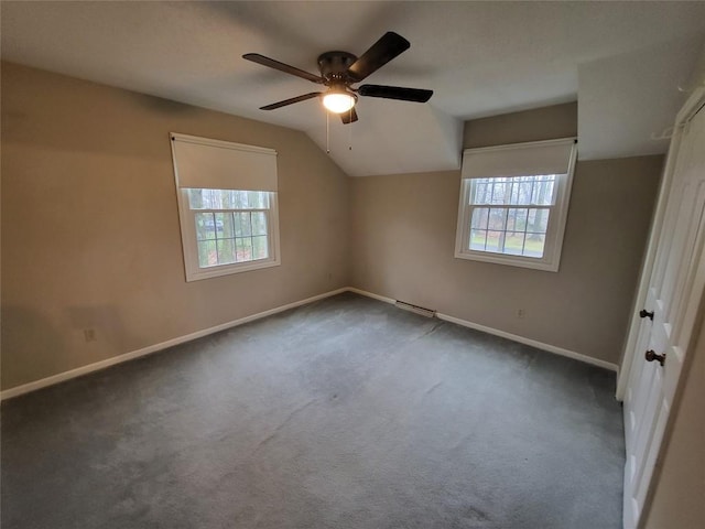 additional living space with plenty of natural light, ceiling fan, and dark carpet