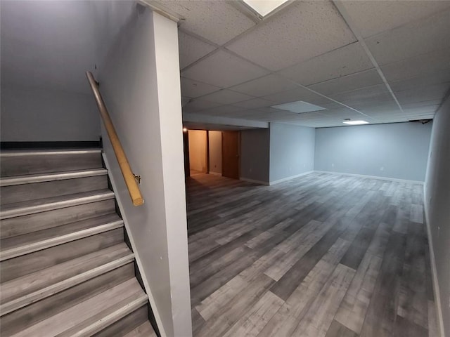 stairway with a paneled ceiling and hardwood / wood-style flooring