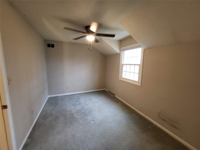 additional living space featuring dark colored carpet and ceiling fan