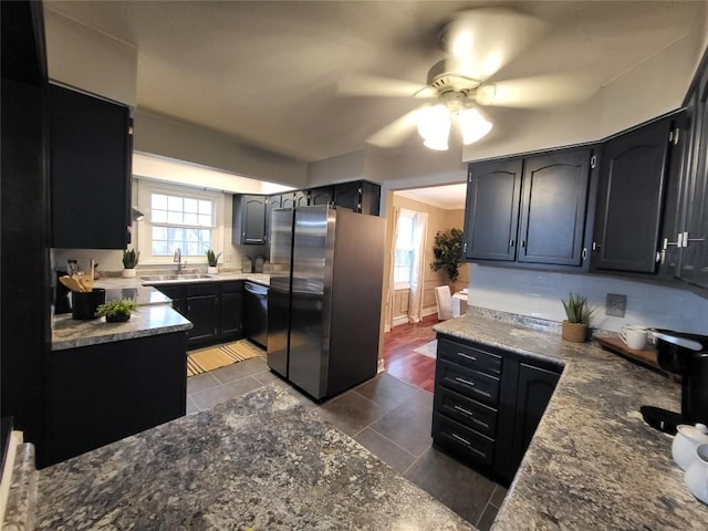 kitchen featuring ceiling fan, dark tile patterned floors, sink, and appliances with stainless steel finishes