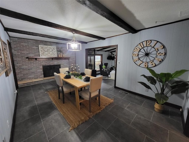 dining room with beamed ceiling, a textured ceiling, a fireplace, and wooden walls