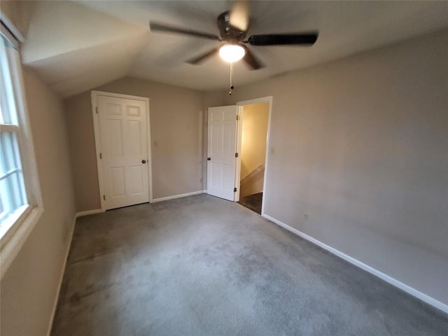 unfurnished bedroom featuring dark carpet, ceiling fan, and lofted ceiling