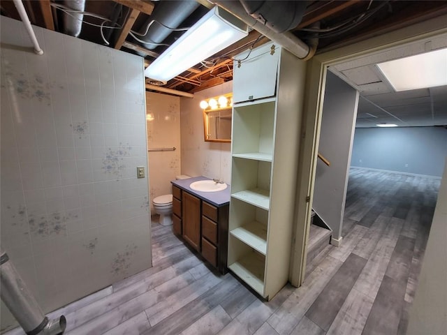 bathroom with toilet, vanity, and hardwood / wood-style flooring