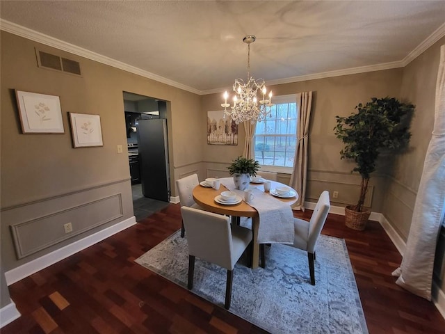 dining area featuring dark hardwood / wood-style floors, crown molding, and a notable chandelier