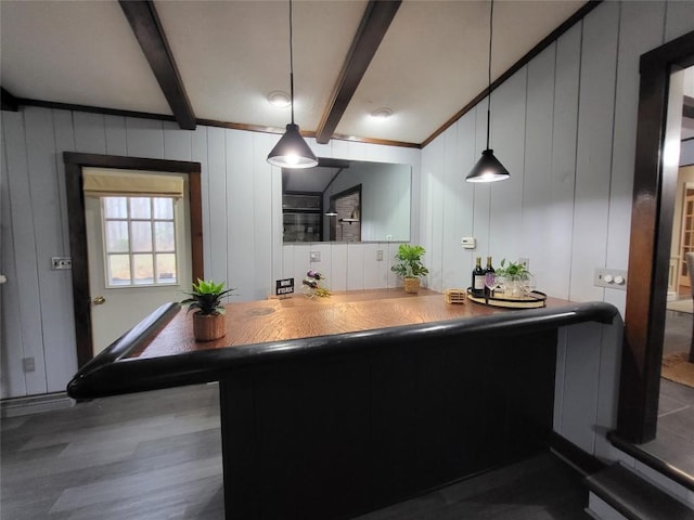 kitchen with pendant lighting, beam ceiling, and dark hardwood / wood-style flooring