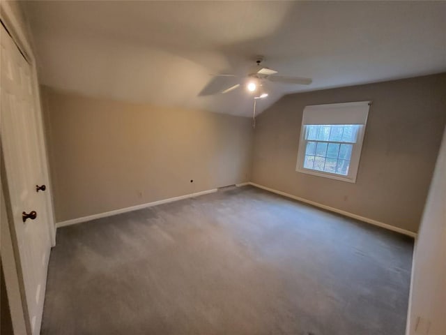 additional living space featuring ceiling fan, vaulted ceiling, and dark colored carpet