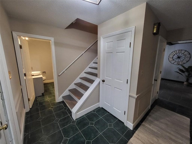 staircase featuring a textured ceiling