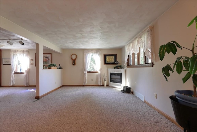 unfurnished living room with carpet floors and rail lighting