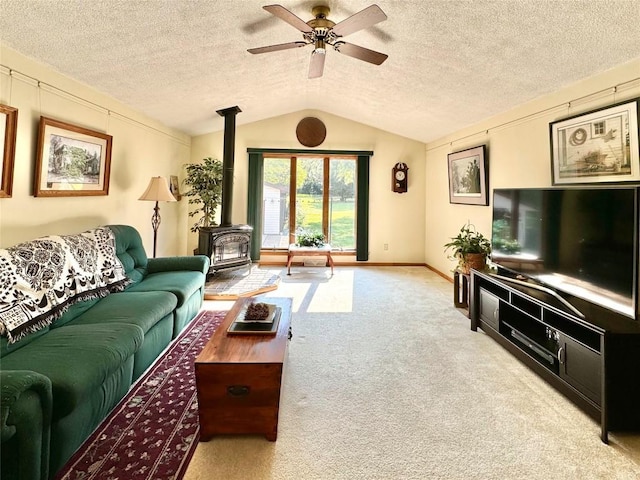 carpeted living room with a textured ceiling, a wood stove, ceiling fan, and lofted ceiling