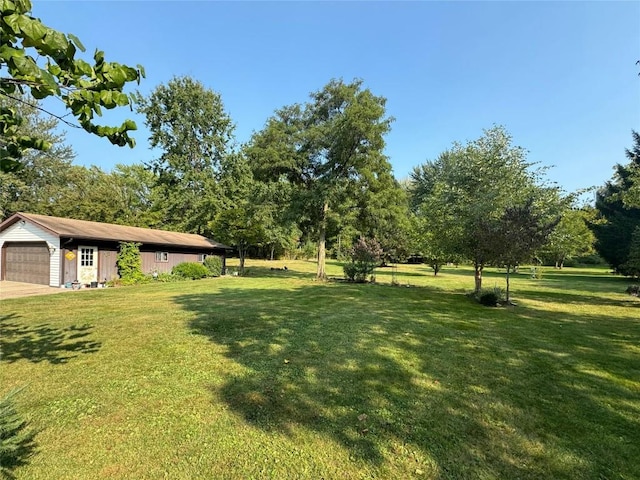 view of yard featuring a garage and an outdoor structure